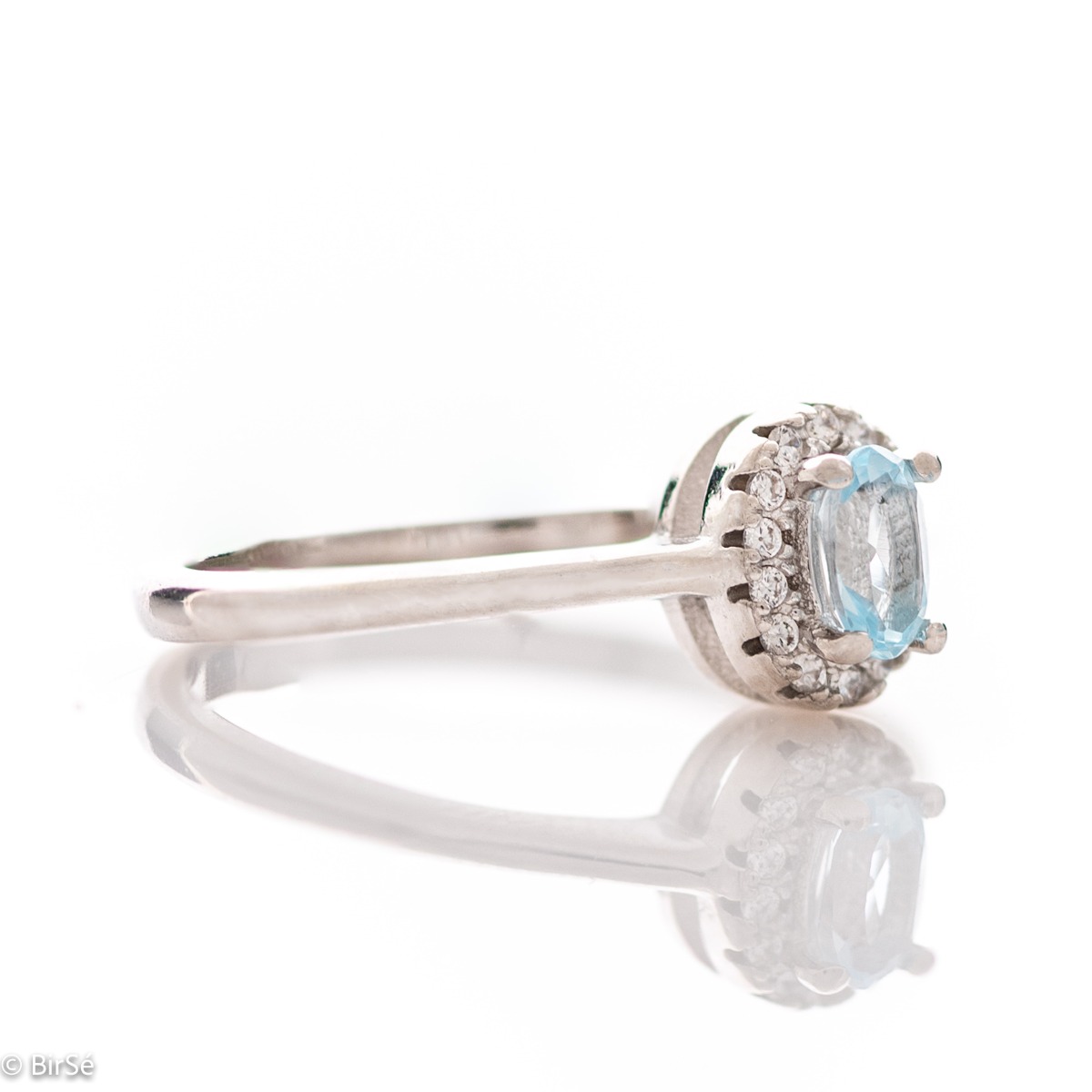 An exquisite women's ring with a tempting natural blue topaz, complemented by the sparkle of fine cubic zirconias and beautifully crafted entirely in rhodium-plated silver. In a charming set with matching earrings, bracelet and necklace.