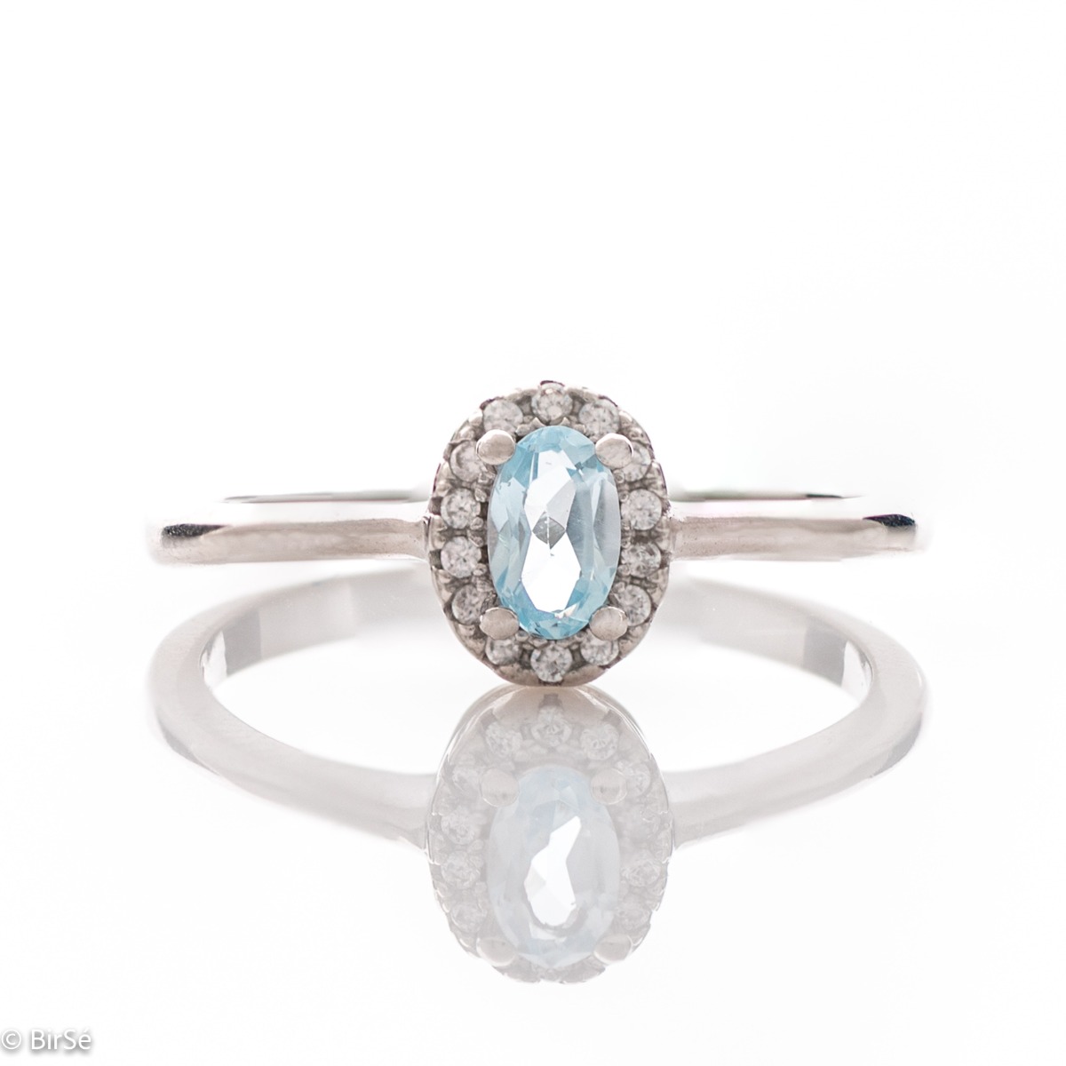 An exquisite women's ring with a tempting natural blue topaz, complemented by the sparkle of fine cubic zirconias and beautifully crafted entirely in rhodium-plated silver. In a charming set with matching earrings, bracelet and necklace.