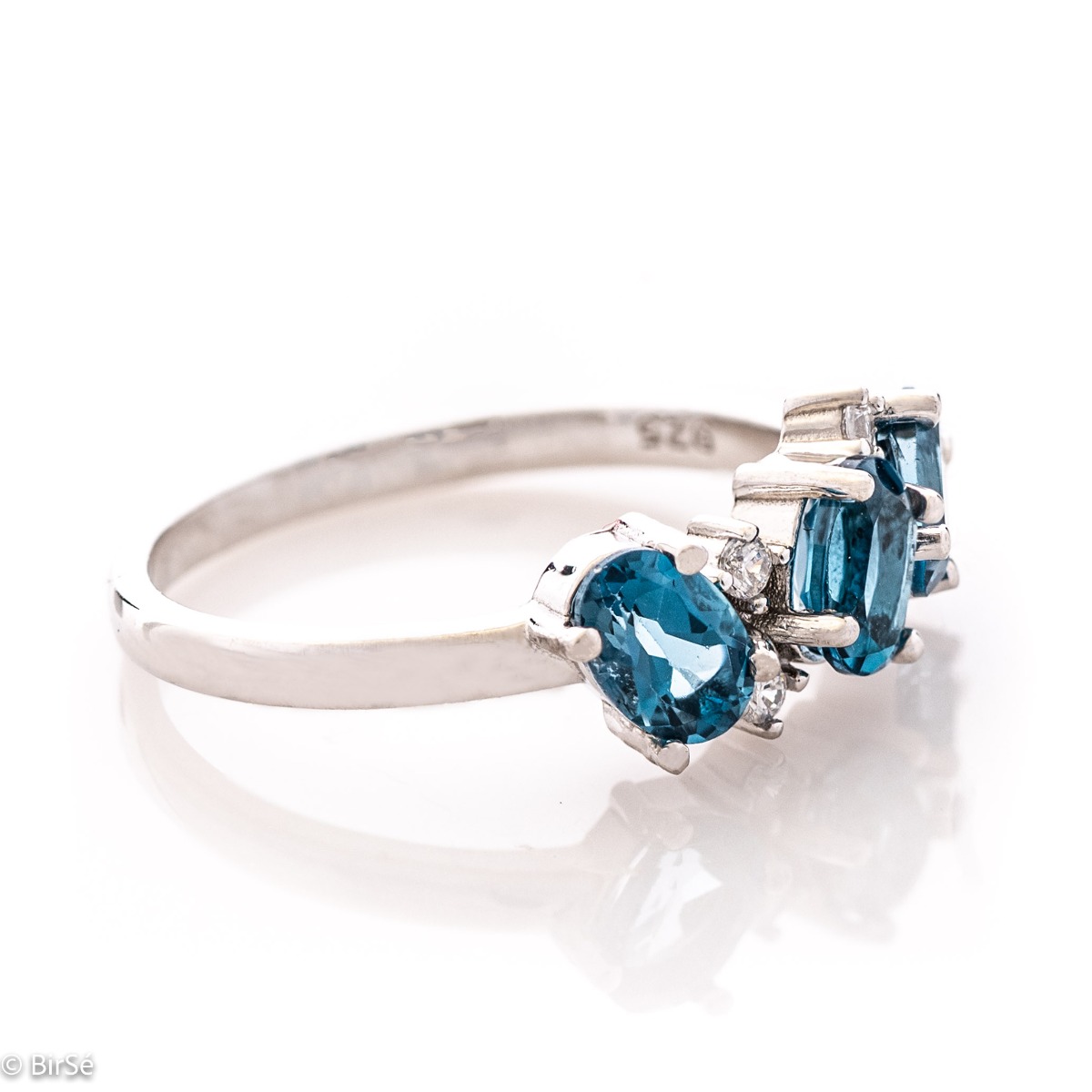 Sparkling ring with exquisite craftsmanship and delicate curves entirely in rhodium silver, a beautiful combination of asymmetric radiant natural London topaz stones complemented with sparkling zircons.