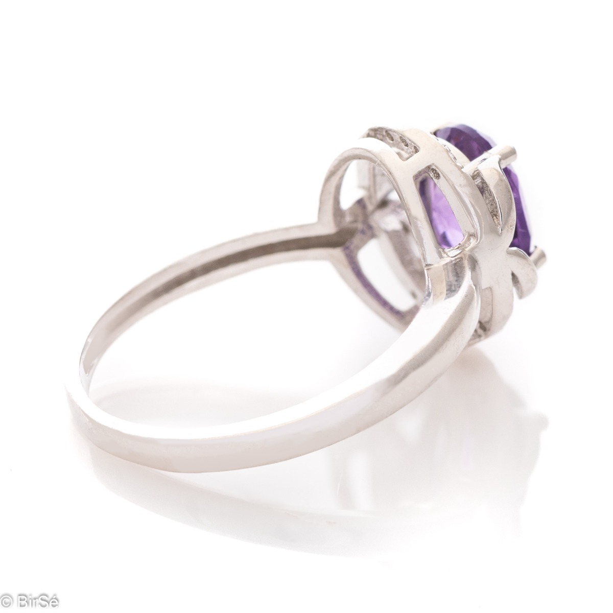 An elegant women's ring, shaped in oval elements and a gentle, beautiful look. Stylish craftsmanship from a fine combination of rhodium silver, zircons and natural amethyst. Complete with the same model of charming English clasp earrings.