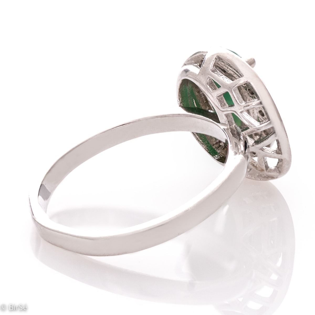 An elegant women's ring with ethereally shaped details, made entirely of rhodium-plated silver in combination with exquisite zircon stones and a captivating emerald.