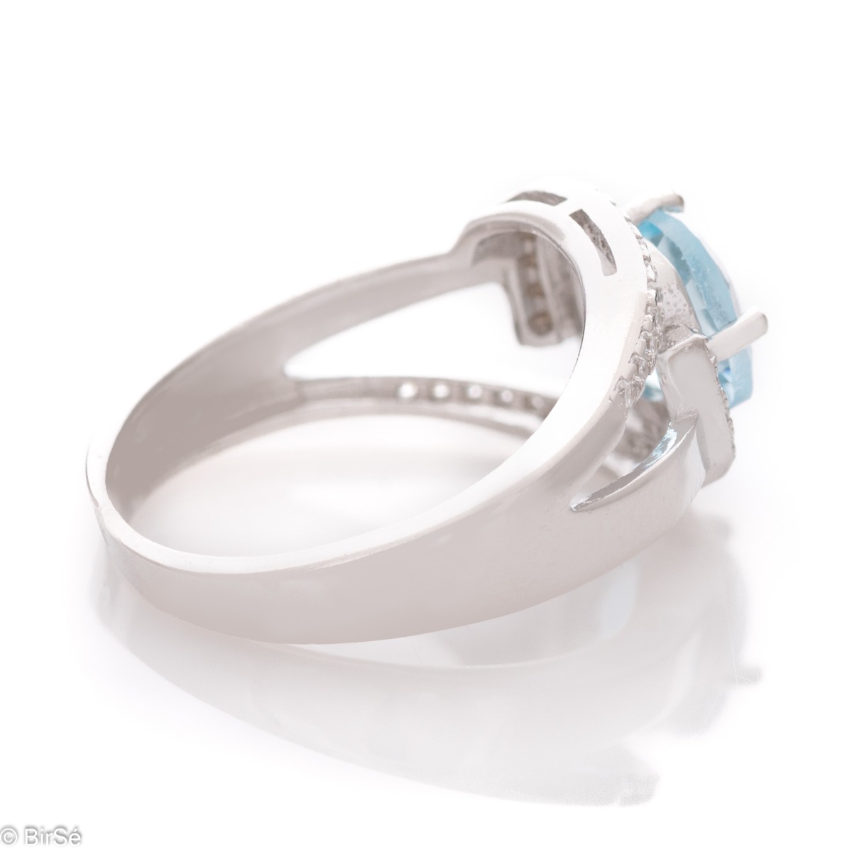 Delicately elegant women's ring with a sophisticated look and fine detailing. Stylish composition made from a sophisticated combination of rhodium-plated silver with spectacular blue topaz and sparkling zircon stones.