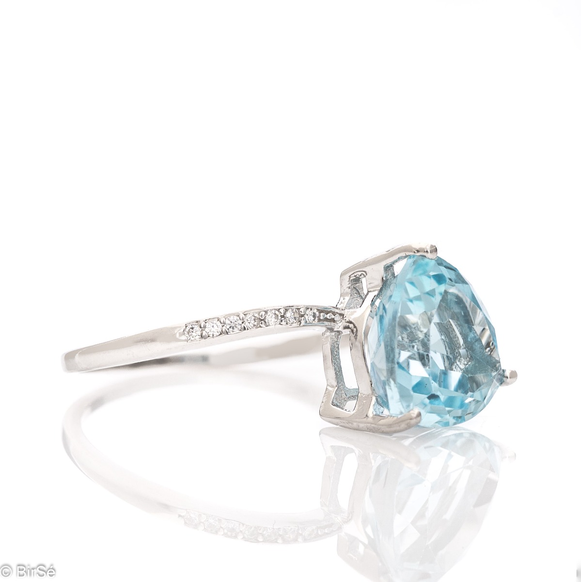 Can there be royal beauty wrapped in a ring? Of course it can. Especially if the work is made of rhodium-plated silver and natural blue topaz, among the delicate shine of zircons.