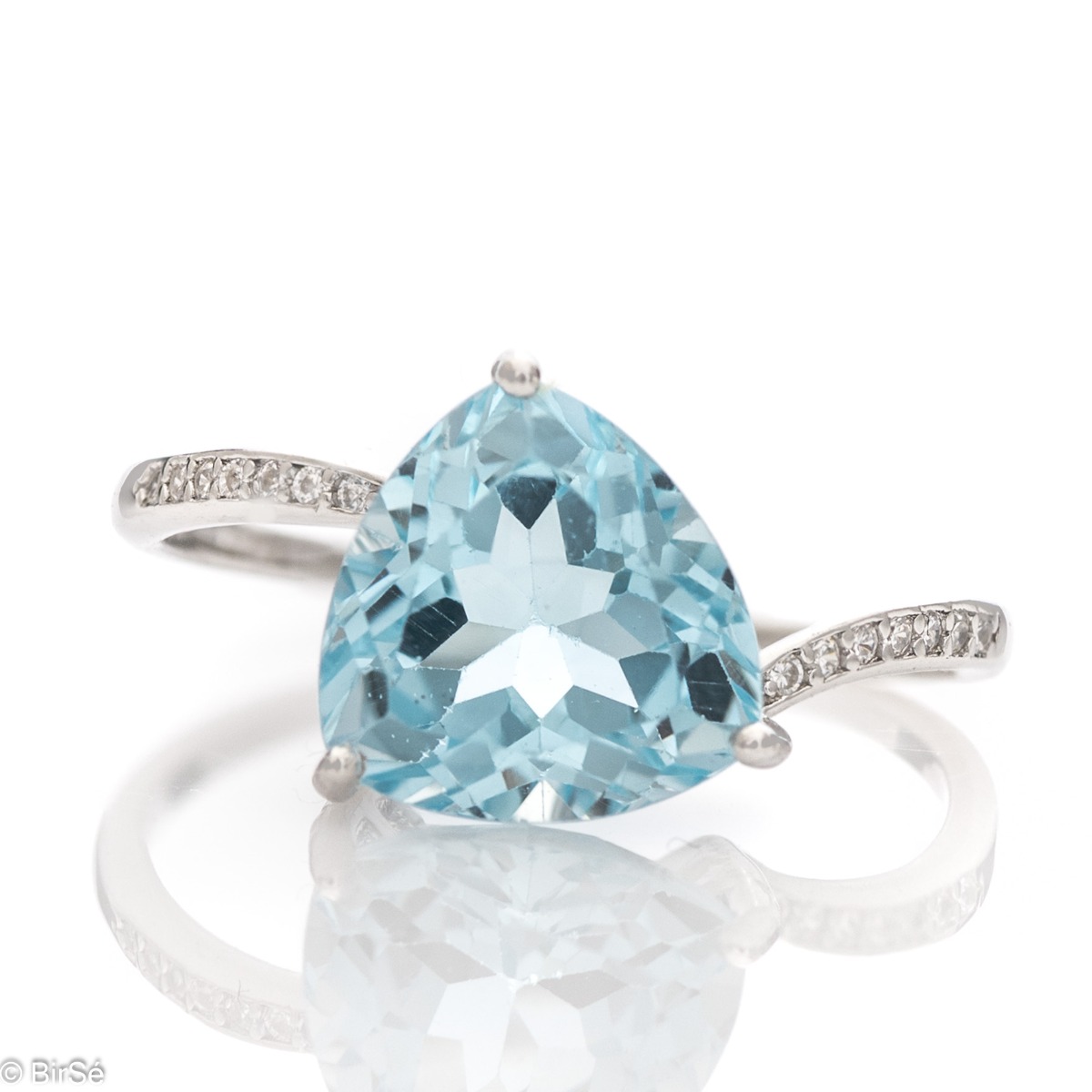 Can there be royal beauty wrapped in a ring? Of course it can. Especially if the work is made of rhodium-plated silver and natural blue topaz, among the delicate shine of zircons.