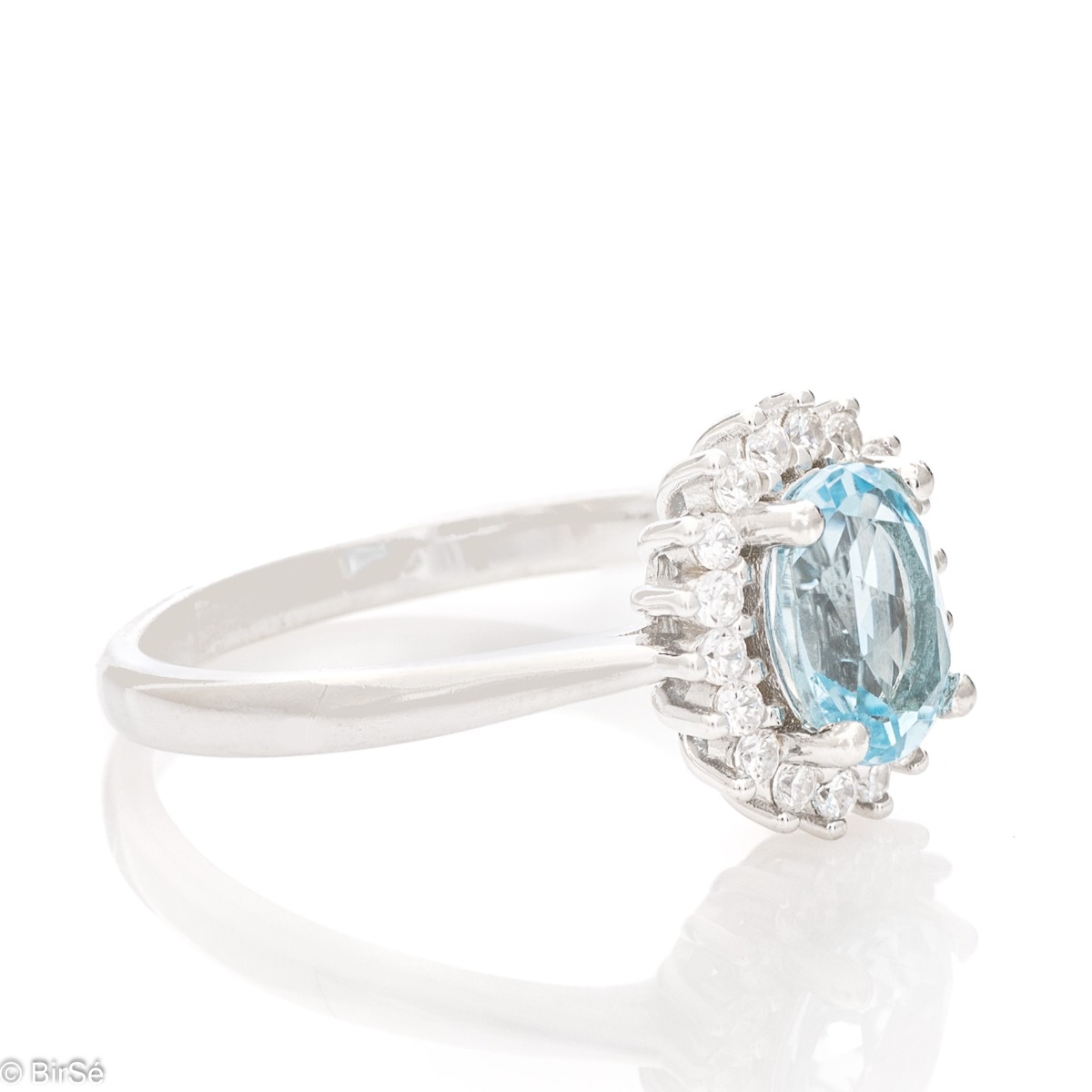 A radiant women's ring with delicate craftsmanship entirely made of rhodium-plated silver, complemented by a unique natural blue topaz stone and the sparkle of fine zircons. Part of an exclusive set with a delicate pendant and earrings.