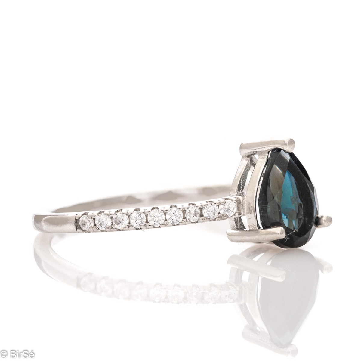 An exceptional women's ring with a radiant natural London topaz surrounded by fine sparkling zircons and exquisitely crafted entirely in rhodium-plated silver.