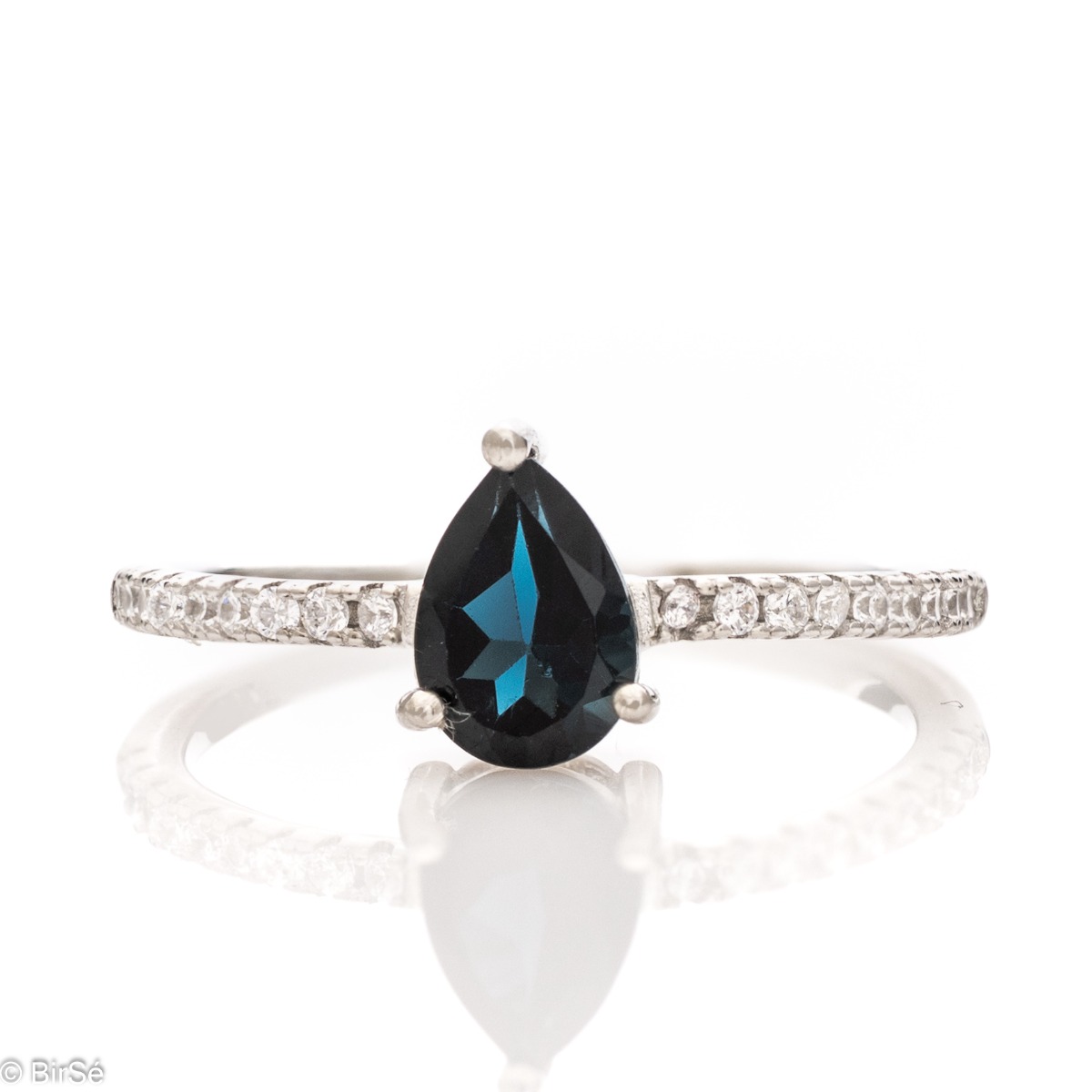 An exceptional women's ring with a radiant natural London topaz surrounded by fine sparkling zircons and exquisitely crafted entirely in rhodium-plated silver.