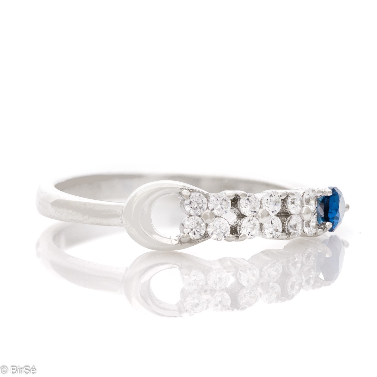 Elegant women's ring with exquisite rhodium-plated silver and radiant sapphire drop, in the company of sparkling zircons.