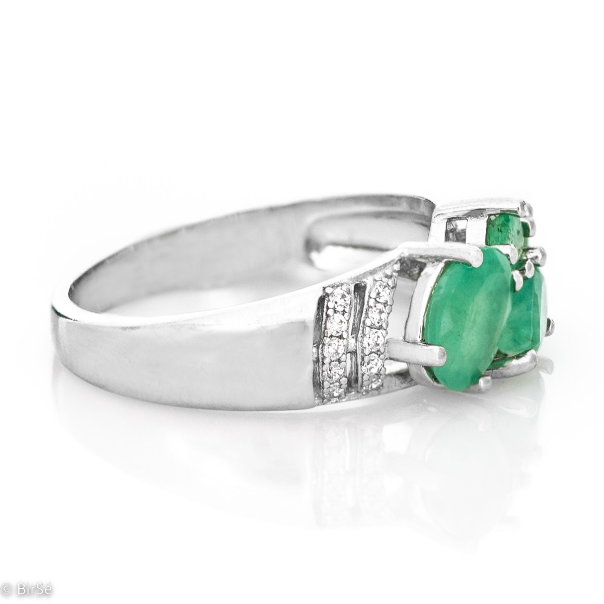 The captivating beauty of natural emeralds expressed in full force in a regal silver ring. The combination with sparkling zircons makes the jewelry even more charming.