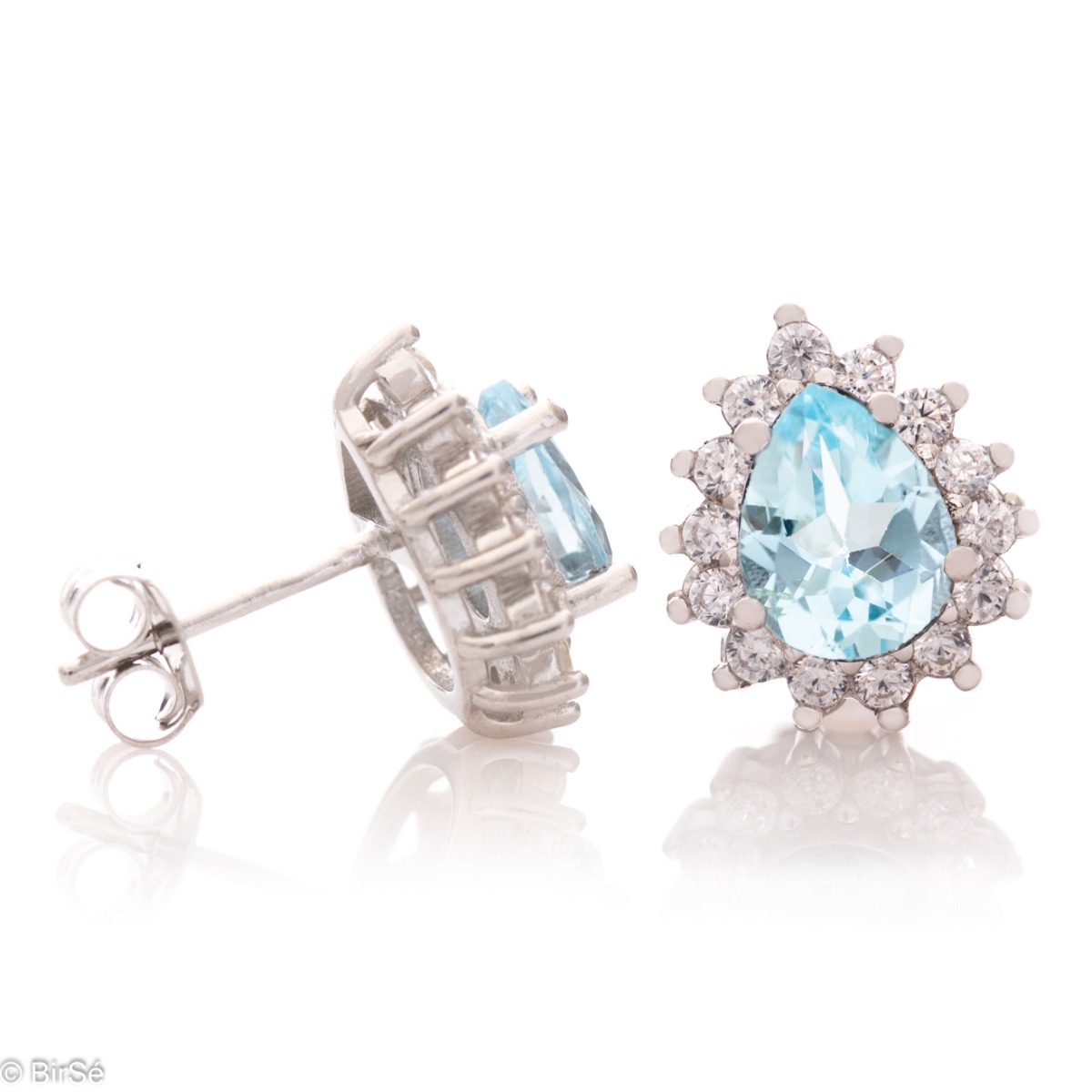 Captivatingly beautiful earrings with natural blue topaz and zircons. The earrings have a delicate drop-shaped design and a pin fastening. In a charming ring and pendant set.