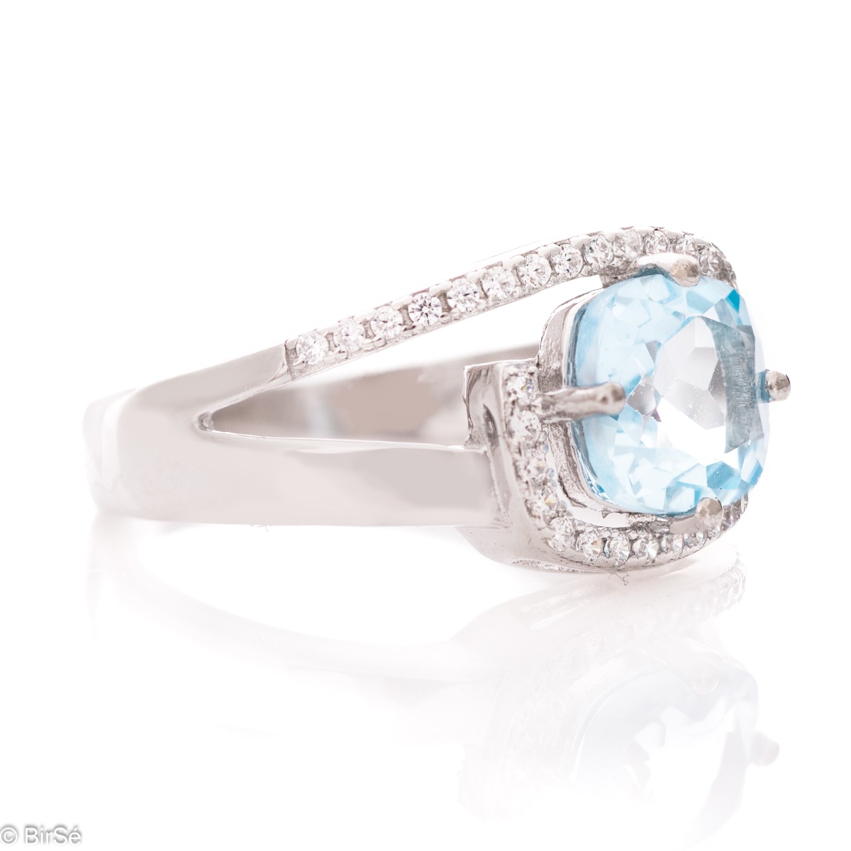 Delicately elegant women's ring with a sophisticated look and fine detailing. Stylish composition made from a sophisticated combination of rhodium-plated silver with spectacular blue topaz and sparkling zircon stones.