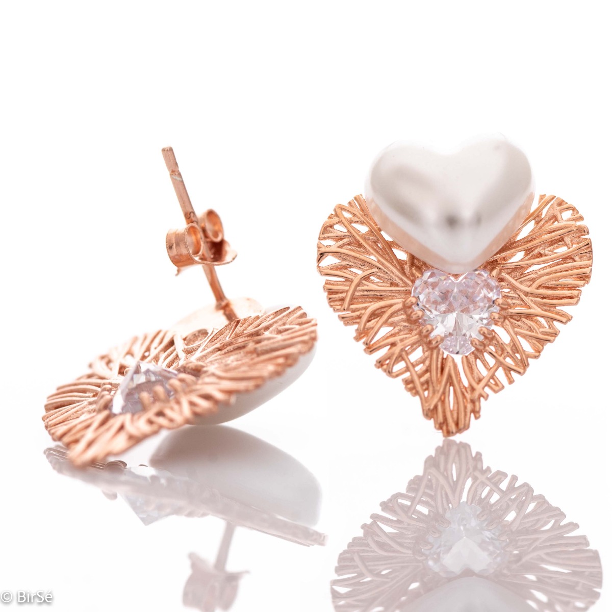 Longing and dreaming of love expressed in the new BirSe earrings. Crafted from fine rose silver, an openwork heart gently wraps around a smaller pearl heart. The jewelry is a suitable gift for the beloved woman.