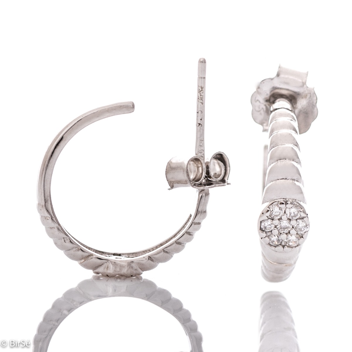 Elegant women's earrings made entirely of fine rhodium-plated silver in the shape of a half-ring. Stylishly decorated with fine zircons, and the fastening is with a pin.