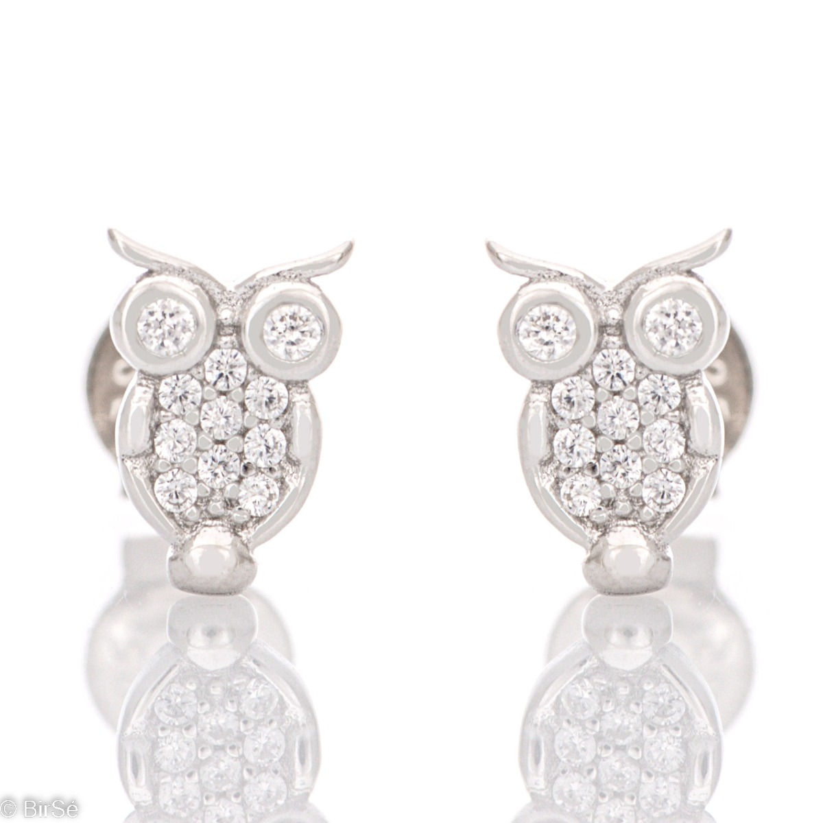 Charming owl earrings elegantly crafted from glittering rhodium silver. The beautiful silver is in the company of fine zircons and together they form delicate earrings that are suitable for little and big girls.