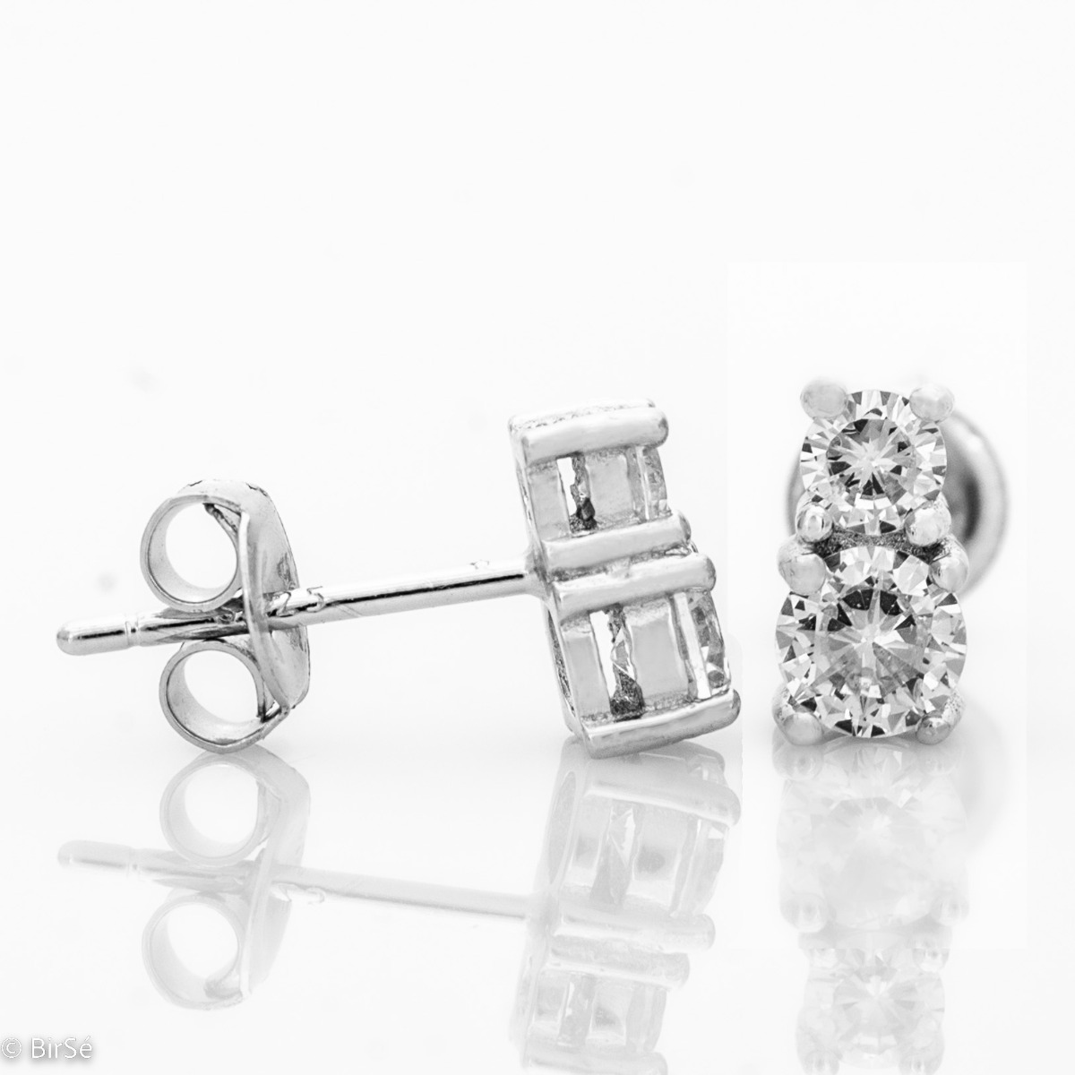 Elegantly crafted women's earrings in fine rhodium silver enclosing a pair of sparkling zircons. The earrings have a pin fastening and are a suitable piece of jewelry for any outfit.