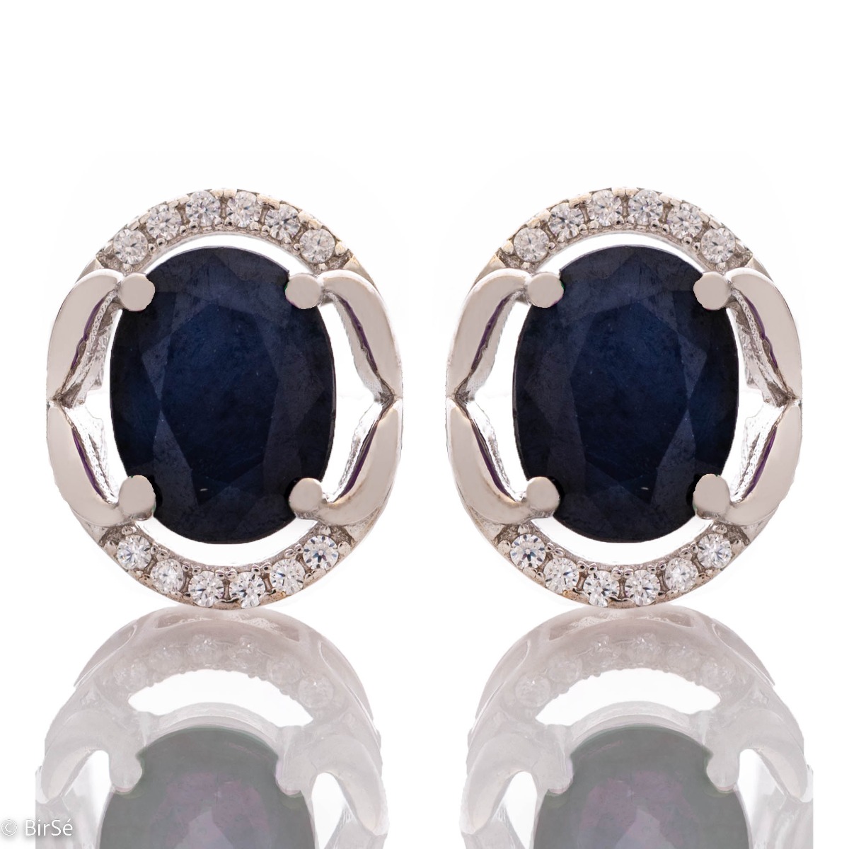 A royal vision - elegant silver earrings with a delicate design. Stylish composition made of a fine combination of rhodium-plated silver with sparkling zircon stones and exquisite sapphire. In a lovely ring and pendant set from the model.