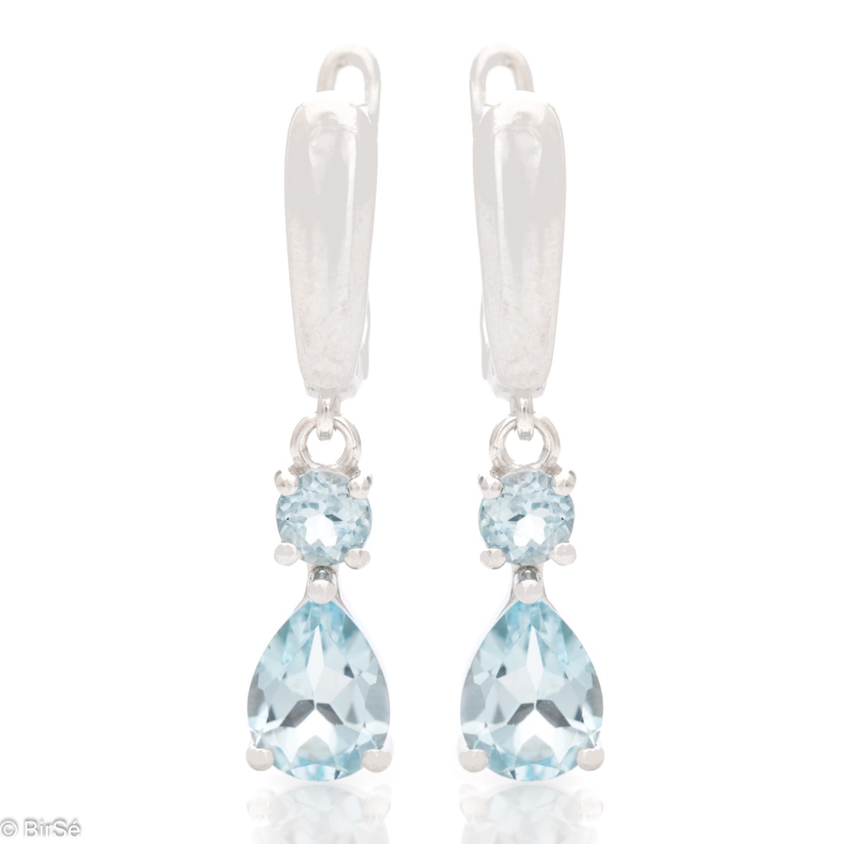 Fancy dangle earrings with English clasp. Finely cast sterling silver and a majestic drop-shaped natural blue topaz. Complete with a ring and pendant with the same elegant design.