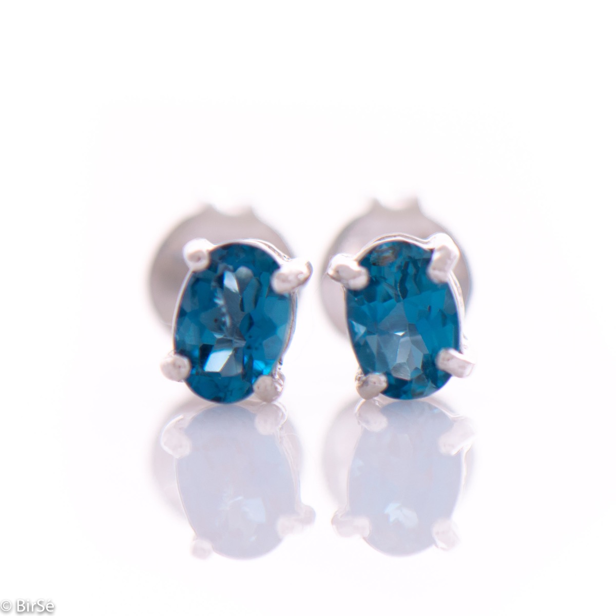 Delicate and radiant stud earrings in rhodium silver with a natural London topaz stone.