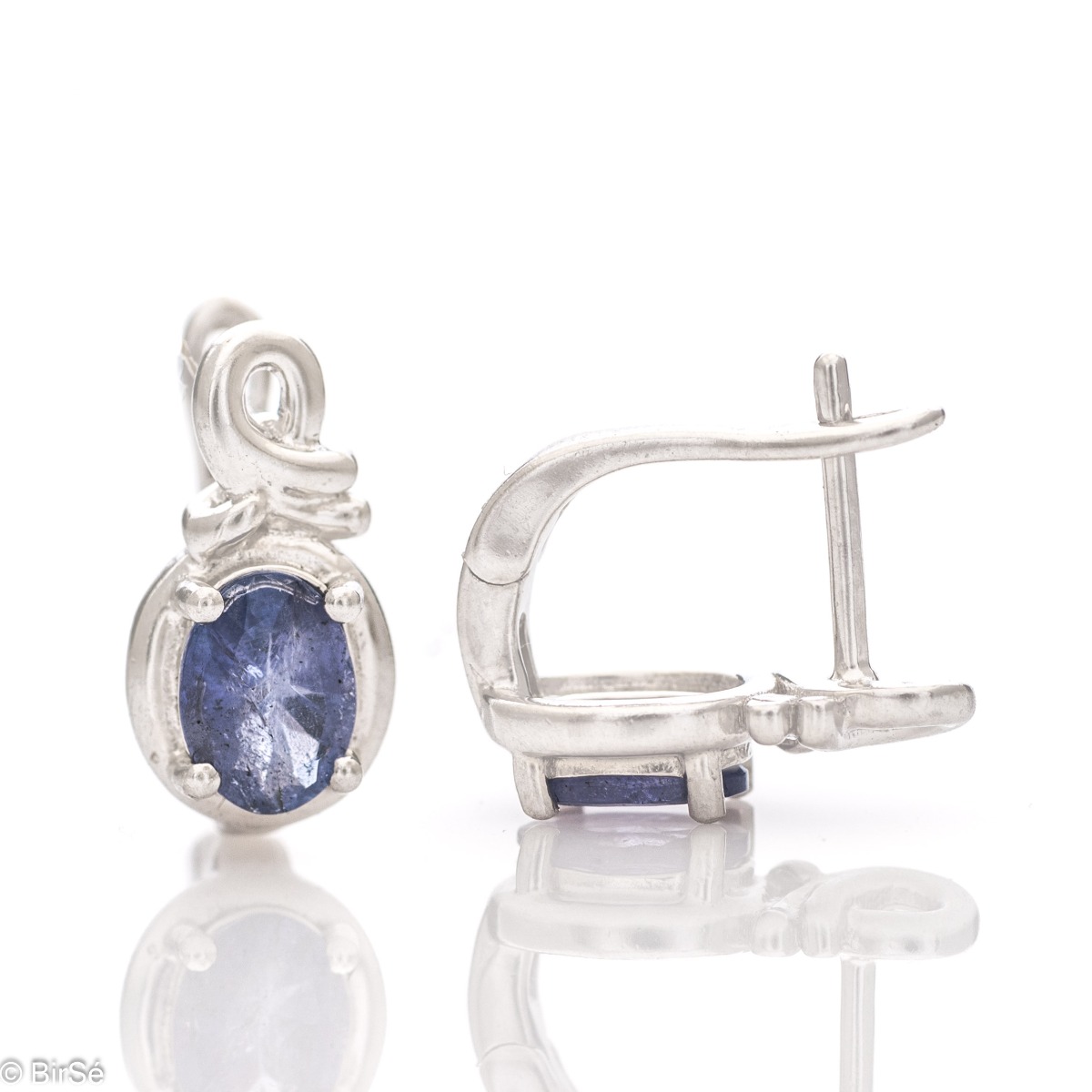 Exquisite ladies' earrings with an English clasp and a gentle interweaving of shiny rhodium silver with a magnetic natural tanzanite stone. They come in an elegant ring and pendant set.