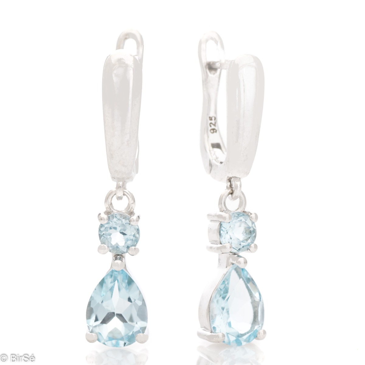 Fancy dangle earrings with English clasp. Finely cast sterling silver and a majestic drop-shaped natural blue topaz. Complete with a ring and pendant with the same elegant design.