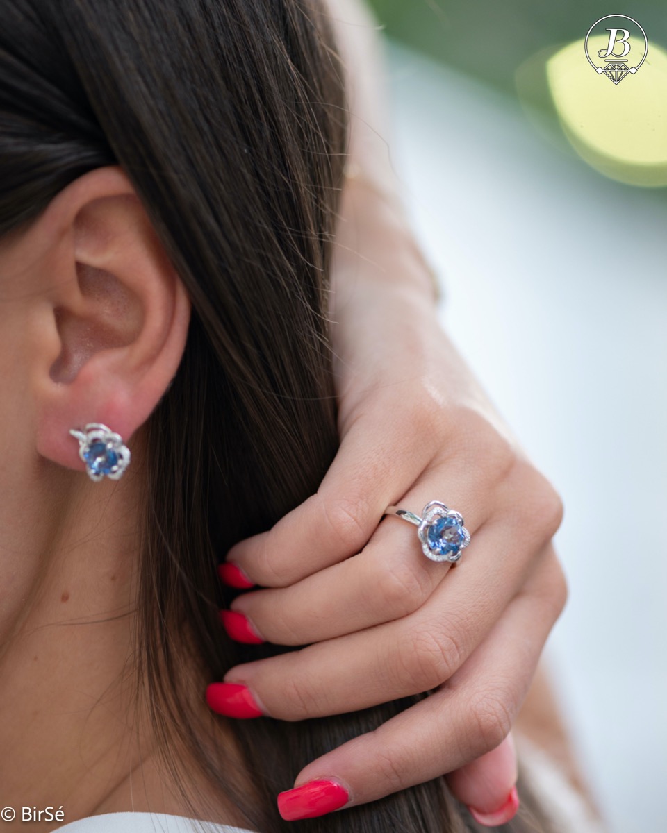 Gentle glow of a natural blue mystic topaz stone complemented by fine sparkling zircons - our new ladies' ring with exquisite details and curves. Part of a charming earring and pendant set.