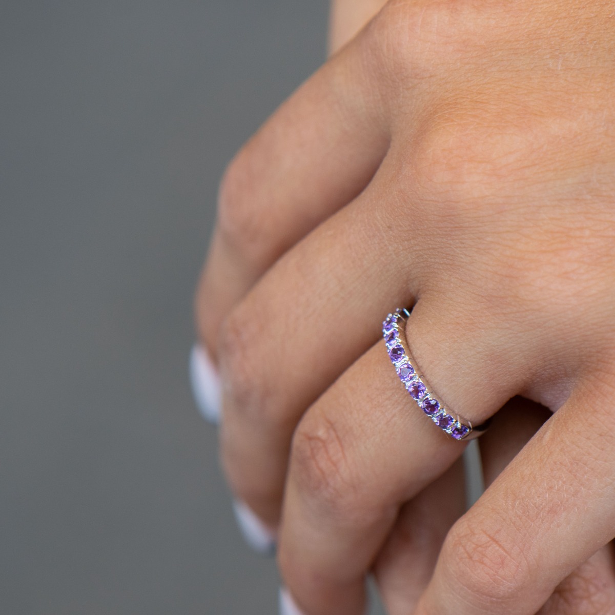 Delicate tempting ring in fine rhodium silver with a row of lovely amethyst stones.