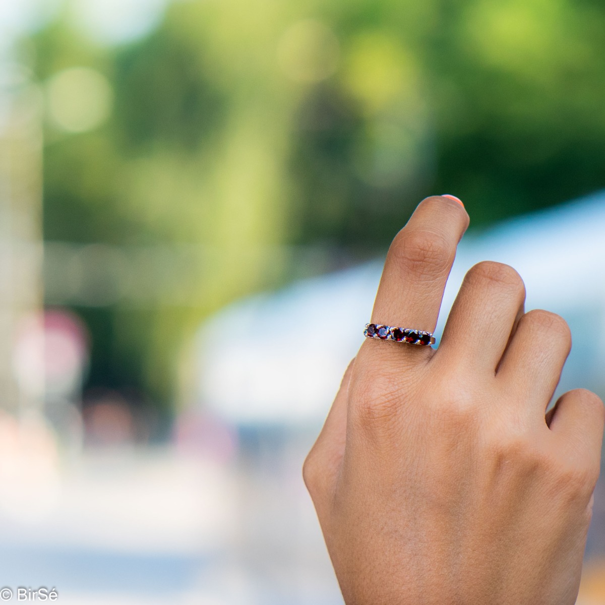 Gentle charm in the form of a lady's ring made of radiant rhodium silver and a row of fine natural garnet stones. A simple yet effective piece of jewelry. It can be combined with a bracelet, earrings and a pendant with garnets. A beautiful gift for any oc