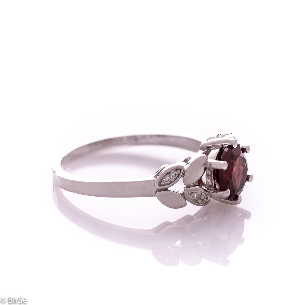 Elegant women's ring with delicate craftsmanship combining refined rhodium-plated silver with radiant natural garnet and petals of sparkling zircons. Can be combined with earrings and pendant of the same model.