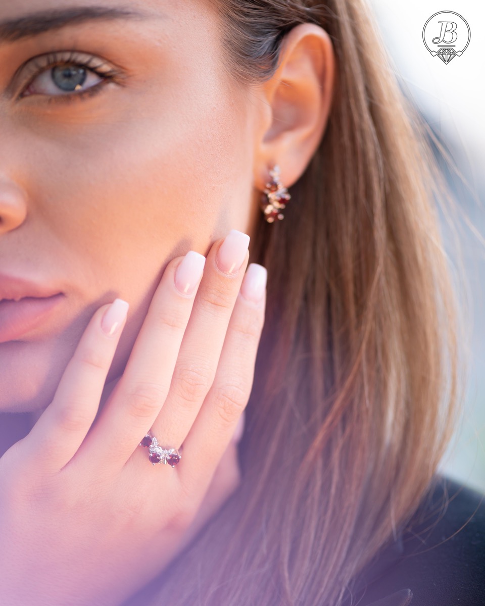 An elegant women's ring with a charming design, combining three radiant natural garnet stones with sparkling zircons and precision craftsmanship entirely in rhodium-plated silver. Can be combined with earrings and pendant of the same model.