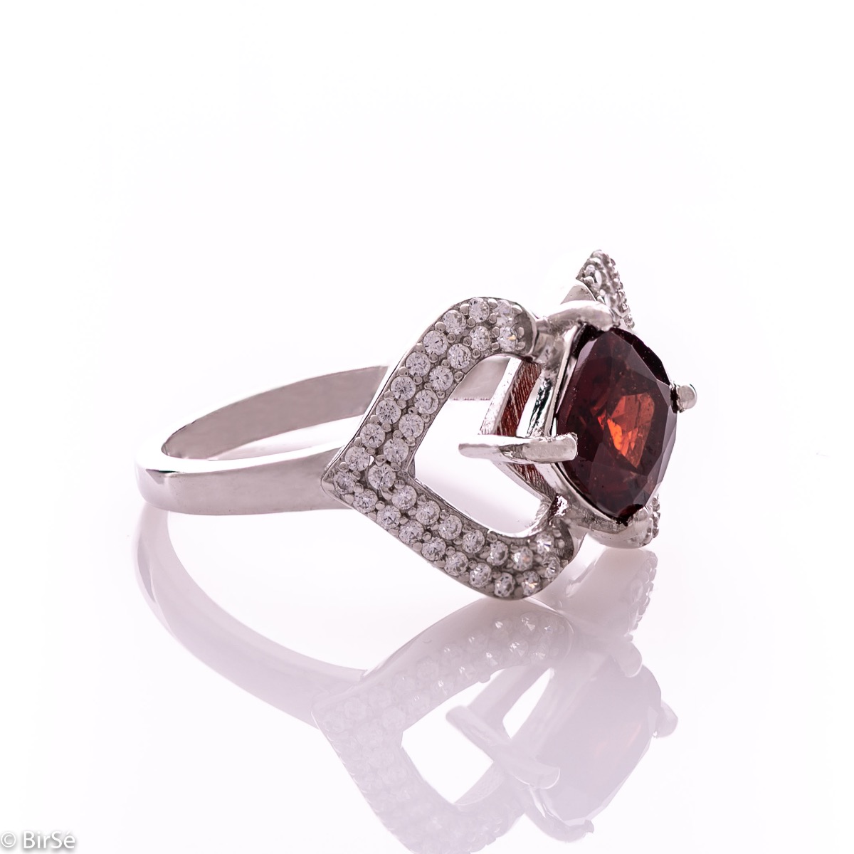 A spectacular women's ring with exquisite workmanship entirely of rhodium-plated silver, combined with a radiant natural garnet stone and sparkling zircons. Can be combined with dangling earrings and a pendant of the same model.