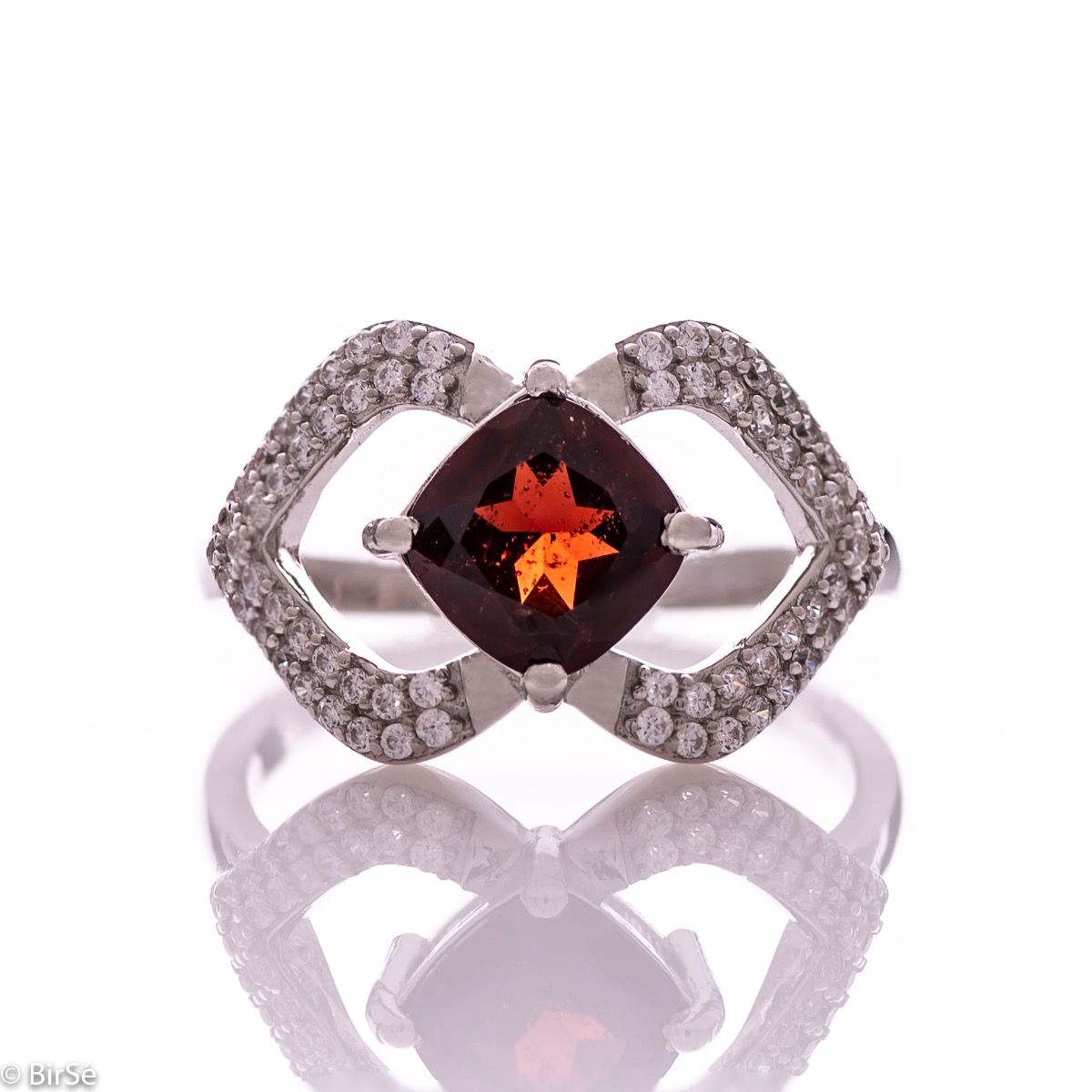 A spectacular women's ring with exquisite workmanship entirely of rhodium-plated silver, combined with a radiant natural garnet stone and sparkling zircons. Can be combined with dangling earrings and a pendant of the same model.