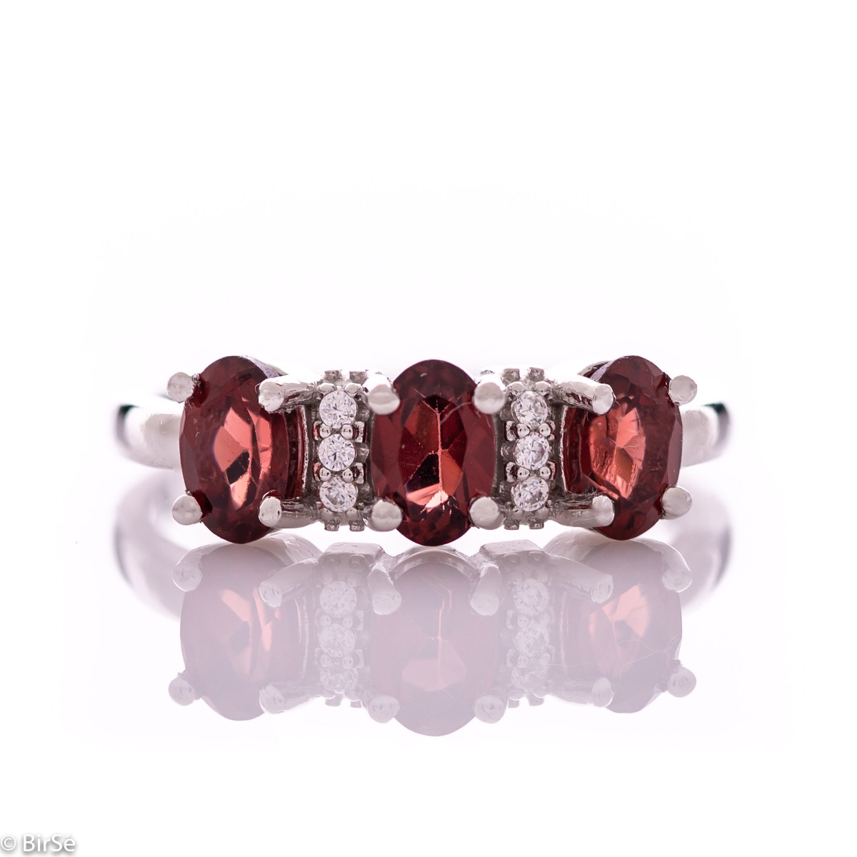 An elegant women's ring with delicate craftsmanship combining rhodium-plated silver with three radiant natural garnet stones and sparkling zircons.