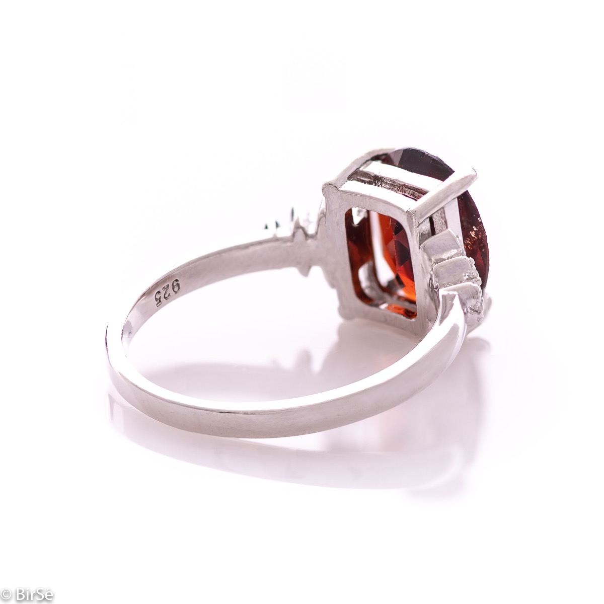 An exquisite women's ring with exceptional workmanship entirely of rhodium-plated silver, combined with a radiant natural garnet and sparkling zircons. Can be combined with earrings and pendant of the same model.