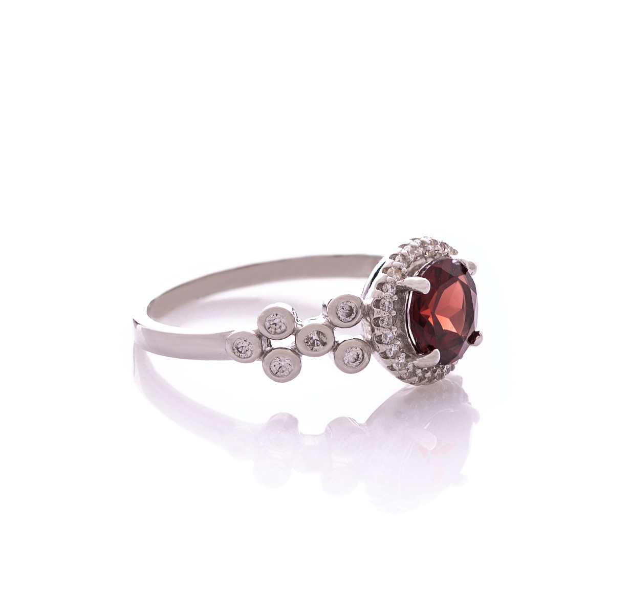 An elegant women's ring with a spectacular workmanship entirely of rhodium-plated silver, combined with a radiant natural garnet and sparkling zircons. Can be combined with earrings and pendant of the same model.