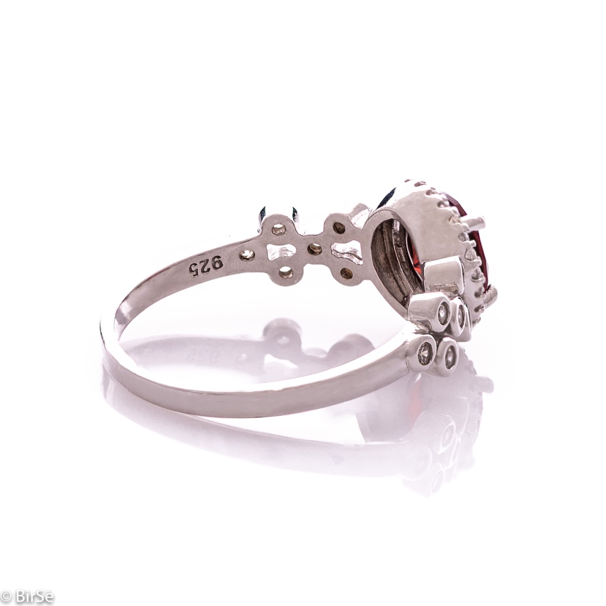 An elegant women's ring with a spectacular workmanship entirely of rhodium-plated silver, combined with a radiant natural garnet and sparkling zircons. Can be combined with earrings and pendant of the same model.