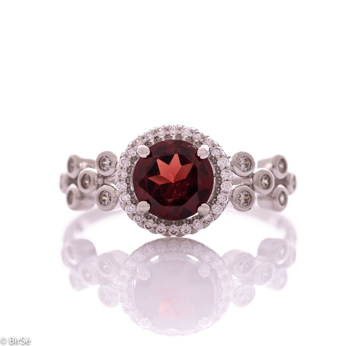 An elegant women's ring with a spectacular workmanship entirely of rhodium-plated silver, combined with a radiant natural garnet and sparkling zircons. Can be combined with earrings and pendant of the same model.