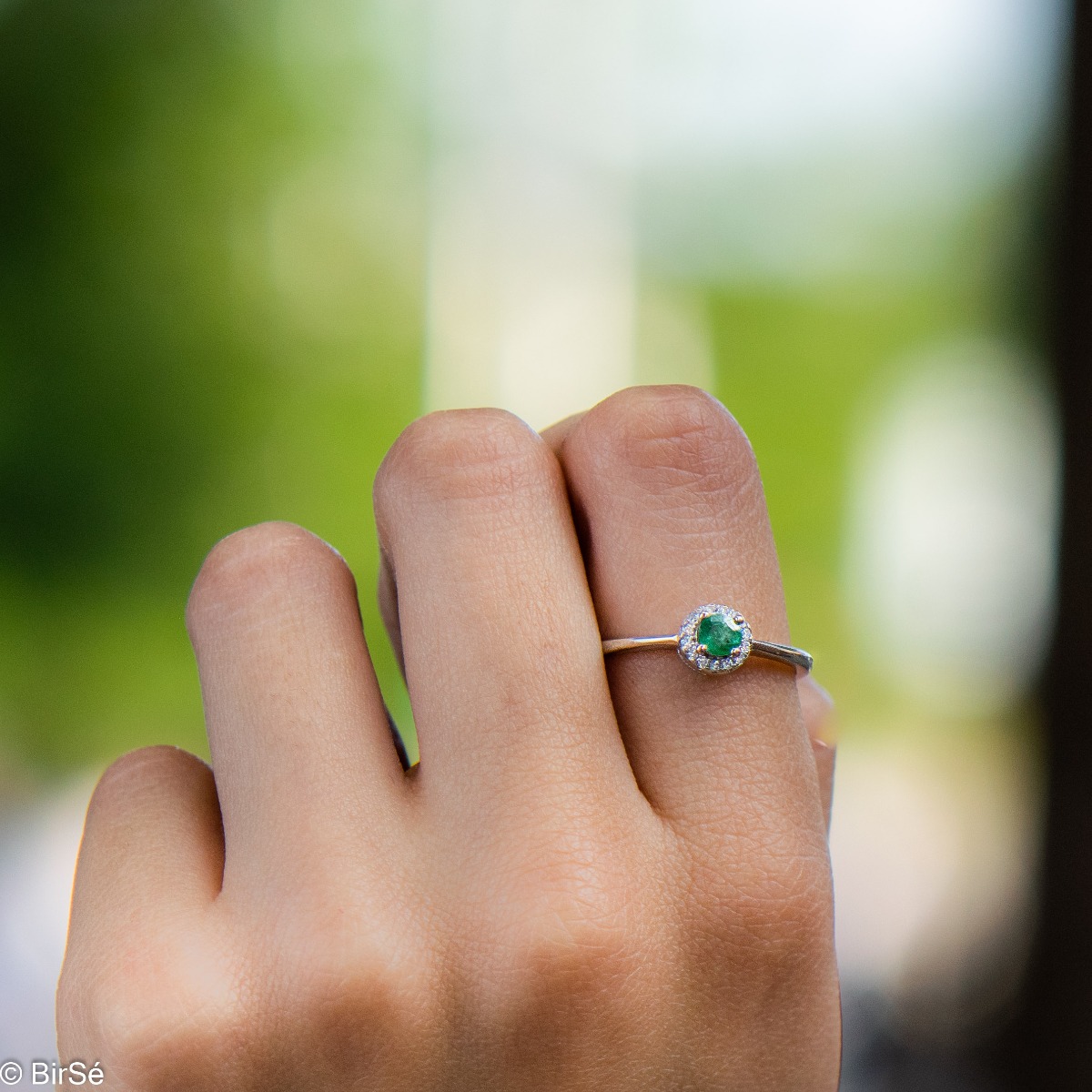 Delicate emerald shine - an extremely beautiful ladies ring with a round shape. Stylish craftsmanship from a fine combination of rhodium silver, fine emerald and sparkling zircons.