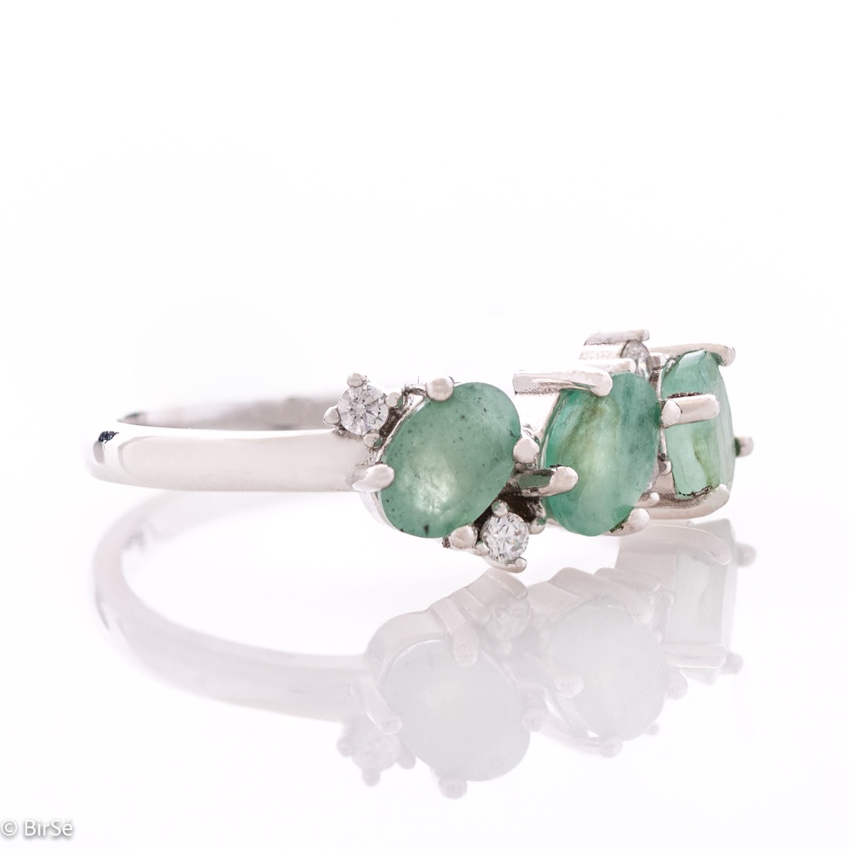 A radiant women's ring with delicate craftsmanship entirely in rhodium-plated silver, complemented by a unique natural emerald stone and the sparkle of fine zircons. Part of an exclusive set with a delicate pendant and earrings.