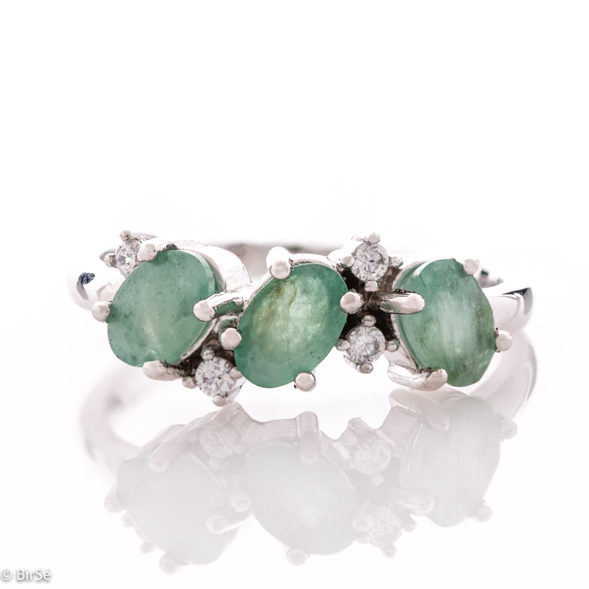 A radiant women's ring with delicate craftsmanship entirely in rhodium-plated silver, complemented by a unique natural emerald stone and the sparkle of fine zircons. Part of an exclusive set with a delicate pendant and earrings.