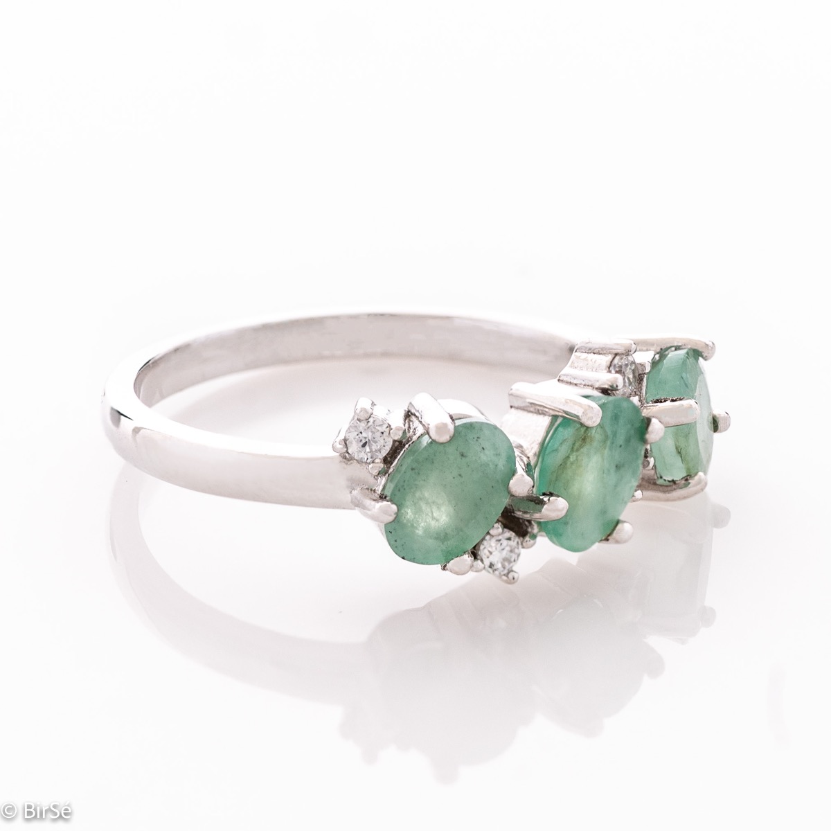 A radiant women's ring with delicate craftsmanship entirely in rhodium-plated silver, complemented by a unique natural emerald stone and the sparkle of fine zircons. Part of an exclusive set with a delicate pendant and earrings.