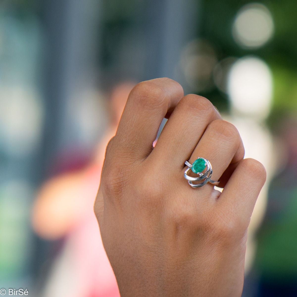 An elegant women's ring with a radiant natural emerald, complemented by sparkling zircons and sophisticated and spectacular craftsmanship entirely in beautiful rhodium-plated silver. In an exclusive set with a pendant and earrings.