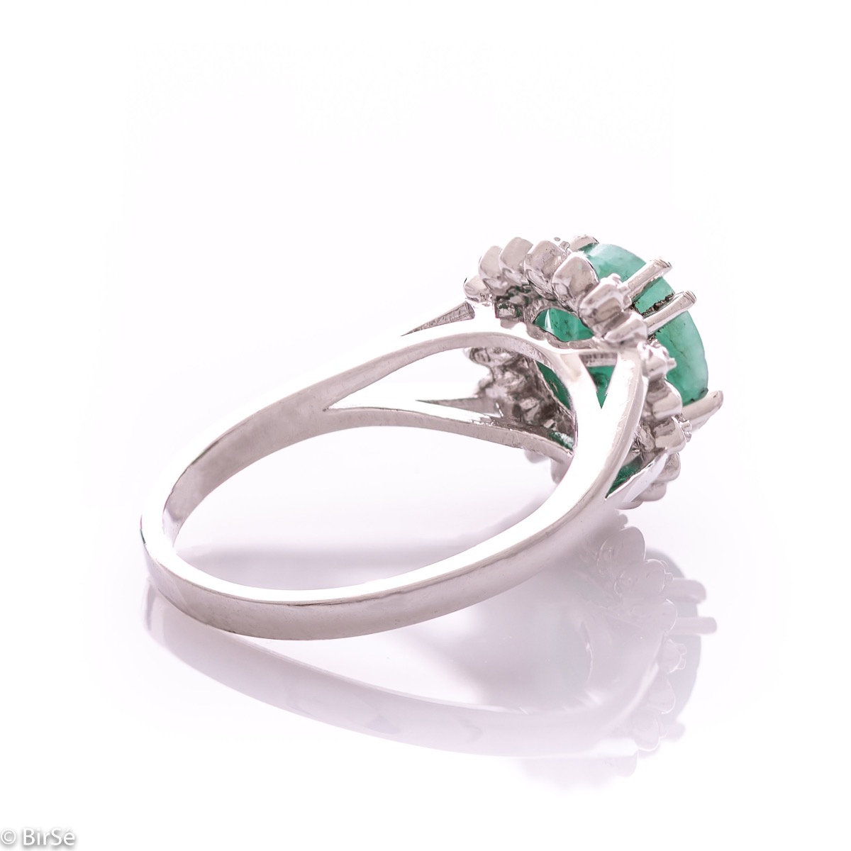 An elegant women's ring with precise craftsmanship combining delicate rhodium-plated silver with a radiant natural emerald surrounded by sparkling zircons. Can be combined with earrings and pendant of the same model.