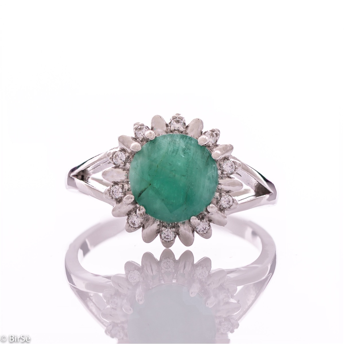 An elegant women's ring with precise craftsmanship combining delicate rhodium-plated silver with a radiant natural emerald surrounded by sparkling zircons. Can be combined with earrings and pendant of the same model.