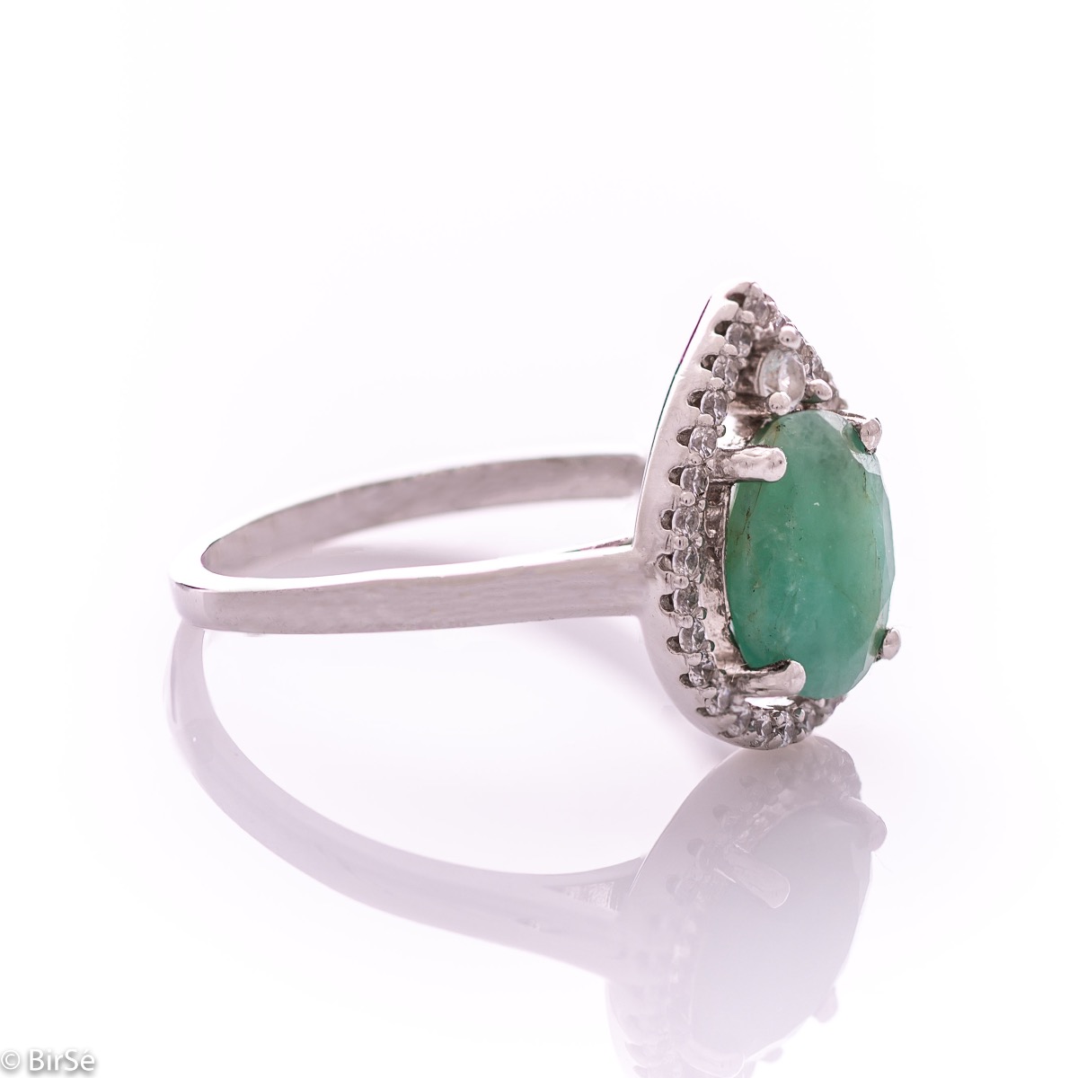 An elegant women's ring with spectacular craftsmanship combining refined rhodium-plated silver with a radiant natural emerald and sparkling zircons. Can be combined with earrings and pendant of the same model.