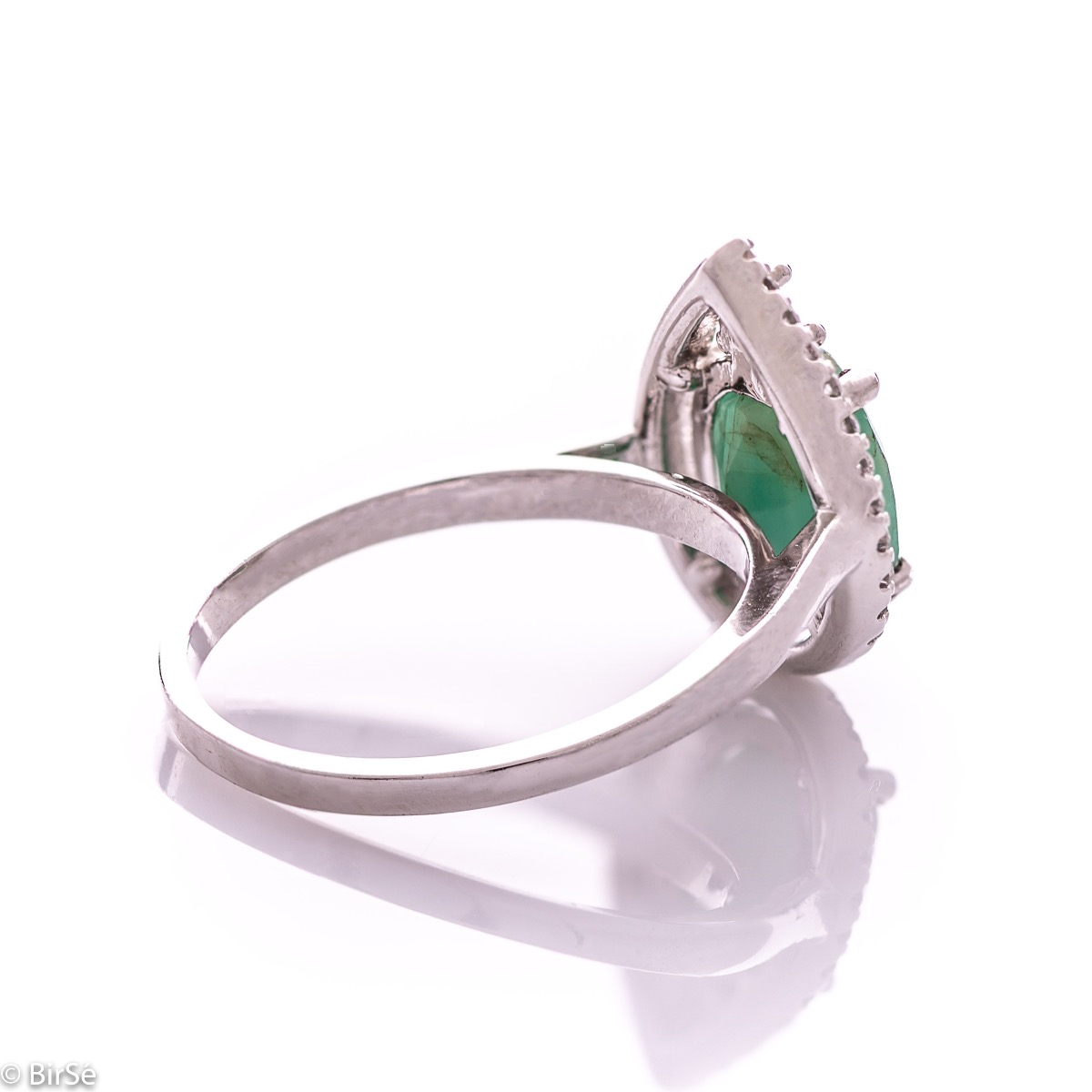 An elegant women's ring with spectacular craftsmanship combining refined rhodium-plated silver with a radiant natural emerald and sparkling zircons. Can be combined with earrings and pendant of the same model.