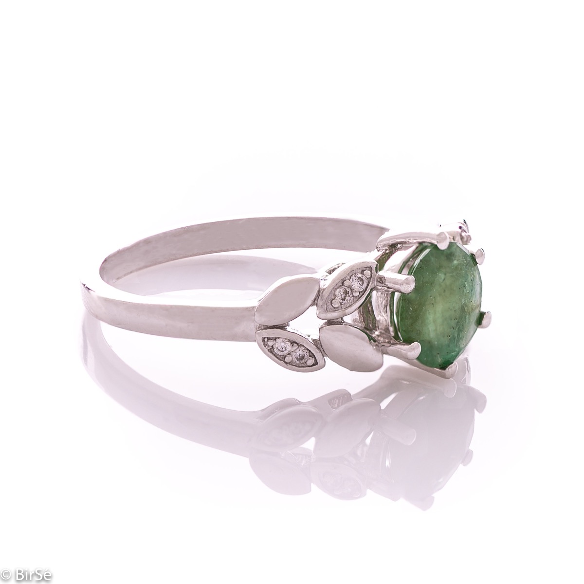 An elegant women's ring with delicate craftsmanship combining refined rhodium-plated silver with a radiant natural emerald and petals of sparkling zircons. Can be combined with earrings and pendant of the same model.