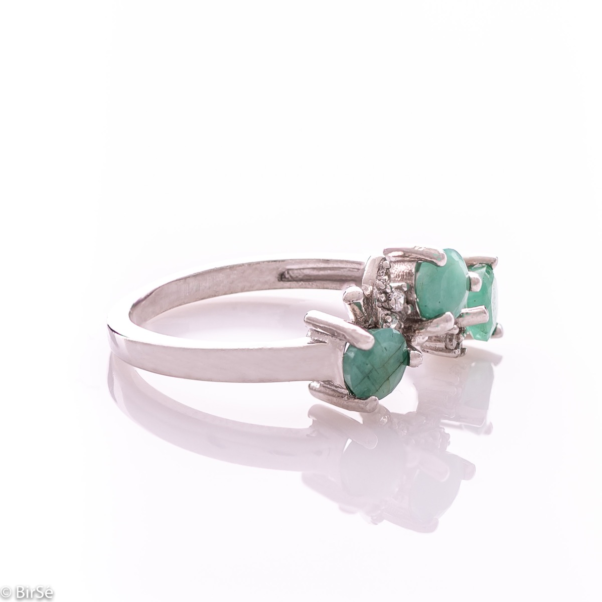 An elegant women's ring with a charming design, combining three brilliant natural emeralds with sparkling zircons and precision craftsmanship entirely in rhodium-plated silver. Can be combined with earrings and pendant of the same model.