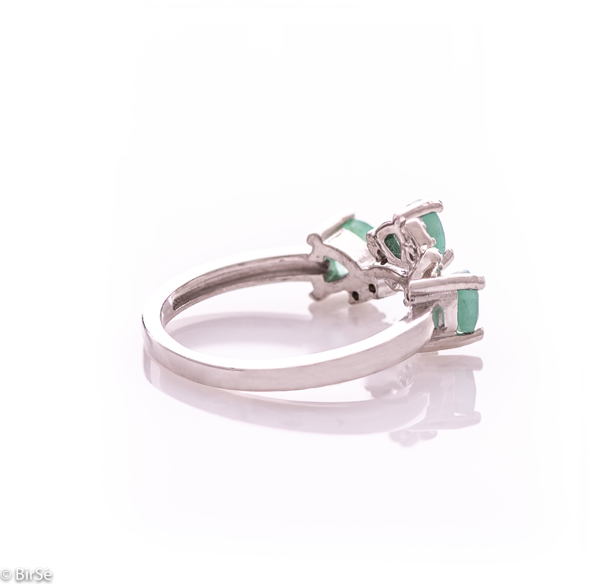 An elegant women's ring with a charming design, combining three brilliant natural emeralds with sparkling zircons and precision craftsmanship entirely in rhodium-plated silver. Can be combined with earrings and pendant of the same model.