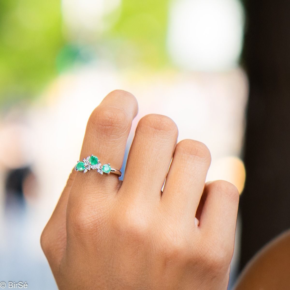 An elegant women's ring with a charming design, combining three brilliant natural emeralds with sparkling zircons and precision craftsmanship entirely in rhodium-plated silver. Can be combined with earrings and pendant of the same model.