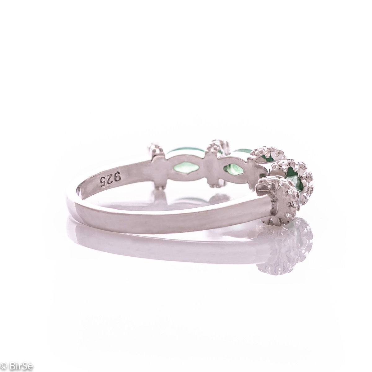 Delicate women's ring intertwining a radiant natural emerald with sparkling zircons and exquisite workmanship entirely in rhodium-plated silver.